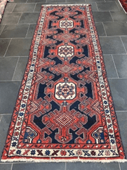 A long rug with red and blue designs on it.