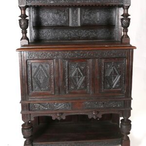 A very old looking cabinet with carvings on it.