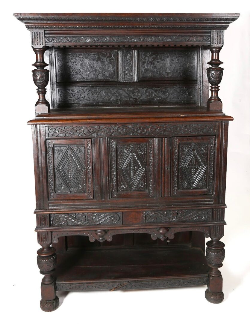 A very old looking cabinet with carvings on it.
