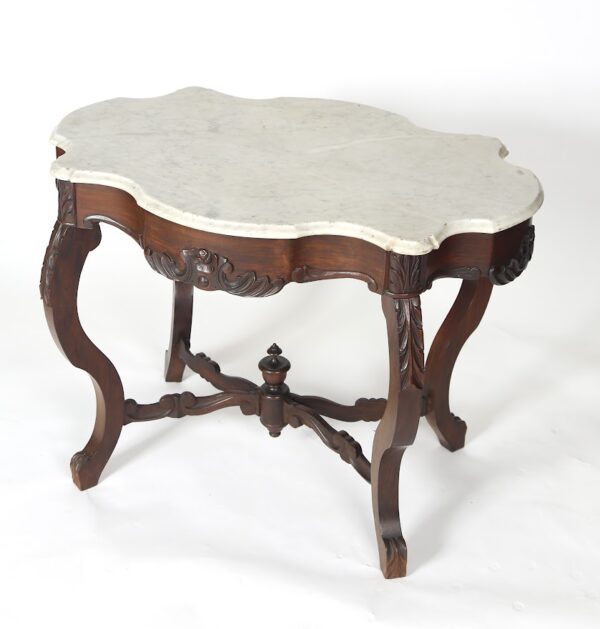 A table with white marble top and wooden legs.