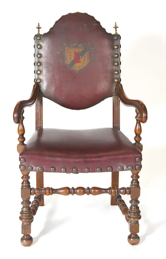A chair with a red leather seat and wooden arms.