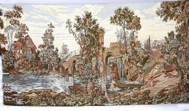 A tapestry with trees, water and buildings.
