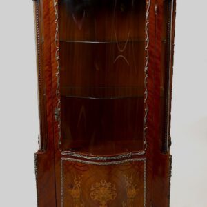 A corner cabinet with an intricate design on the front.