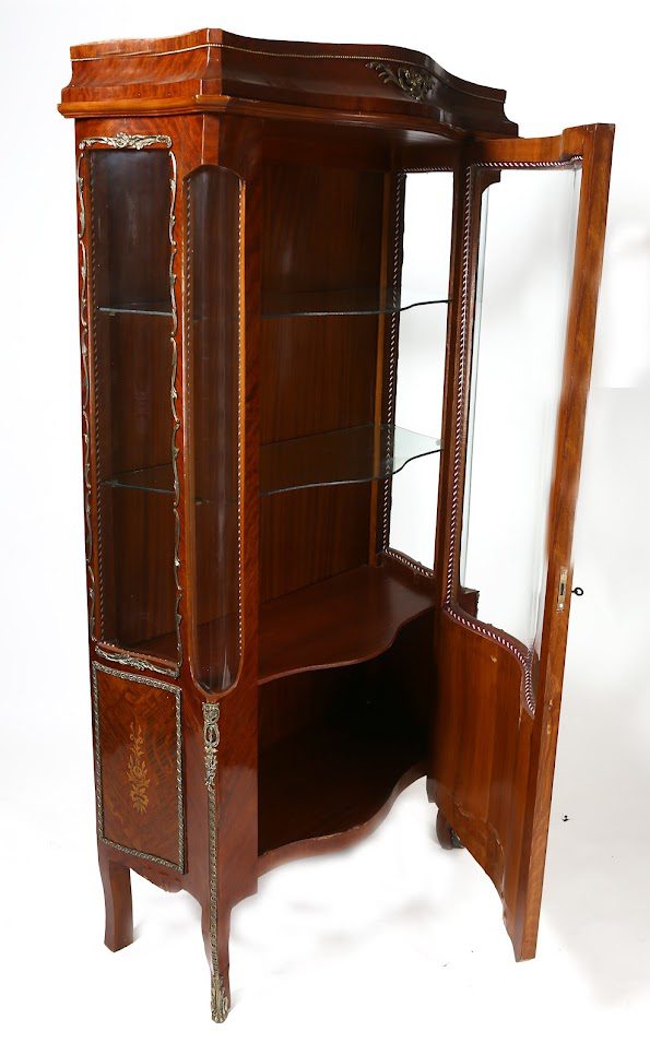 A corner cabinet with glass doors and shelves.