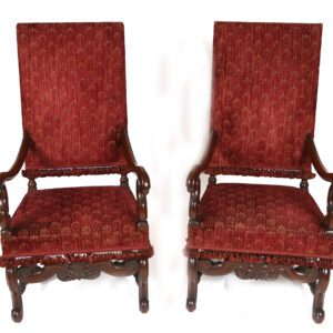 A pair of red chairs with arms and backs.