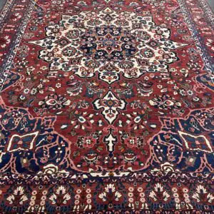 A large oriental rug is shown in the middle of a room.