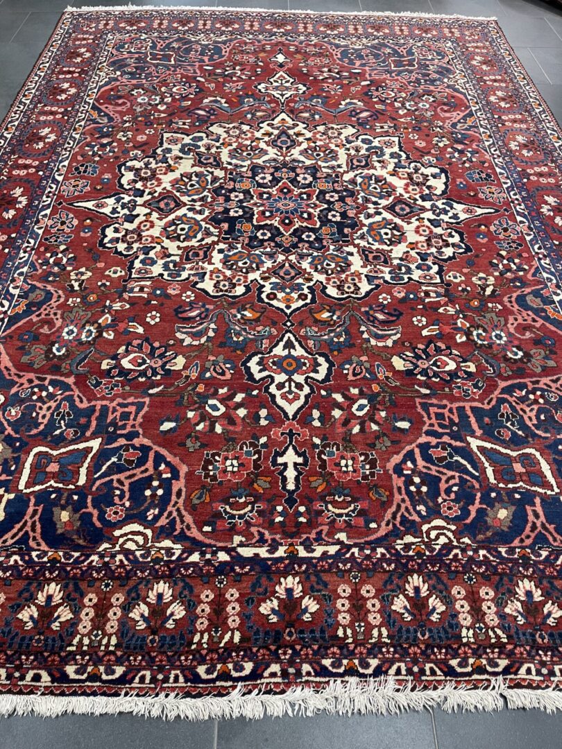 A large oriental rug is shown in the middle of a room.