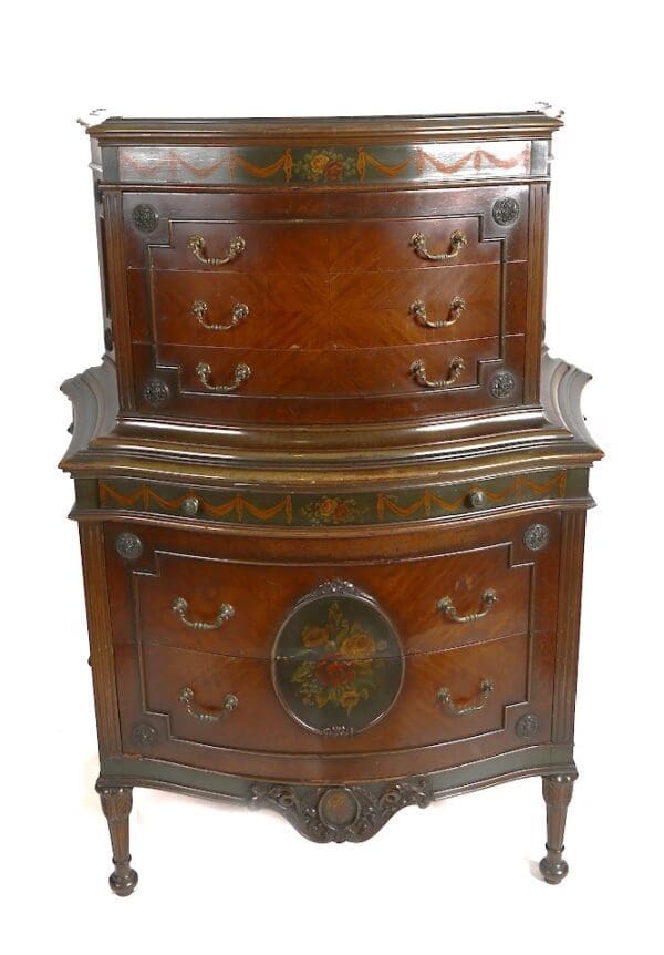 Antique wooden chest of drawers with floral designs.