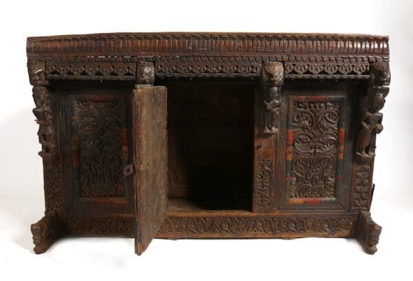 Ornate carved wooden cabinet with open doors.