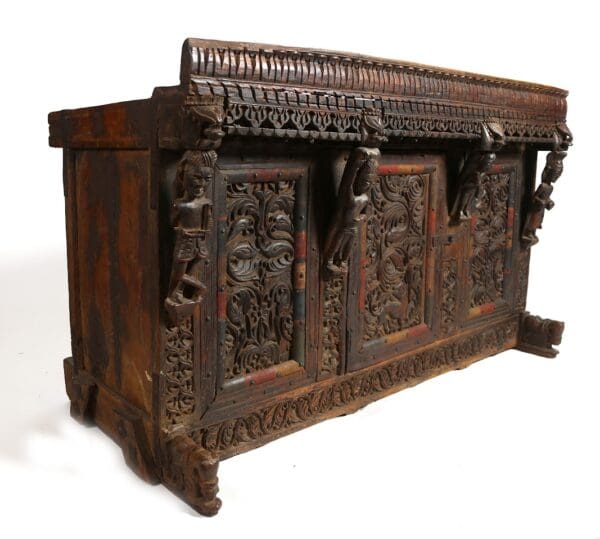 Intricately carved wooden chest with figures.