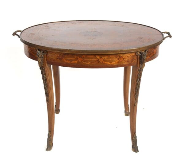 Ornate oval table with brass handles.