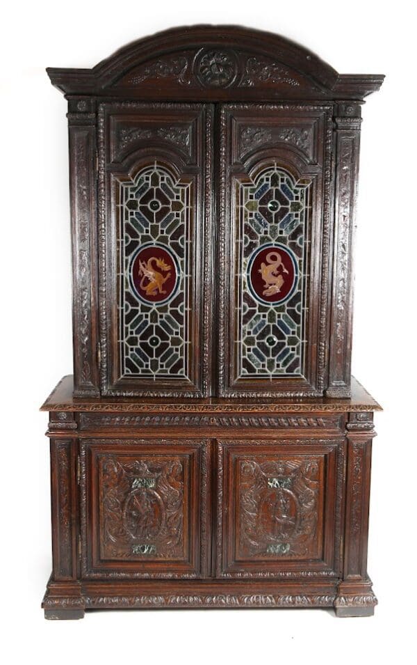 Carved wooden cabinet with stained glass doors.