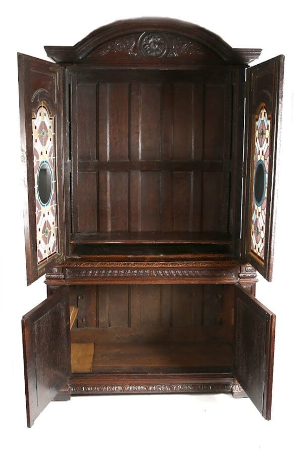 Antique wooden cabinet with stained glass doors.