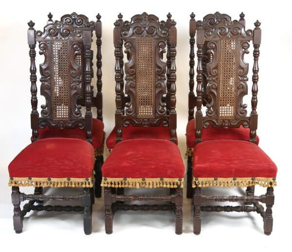 Four ornate wooden chairs with red upholstery.