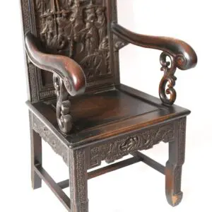 Ornate carved wooden armchair with figures.