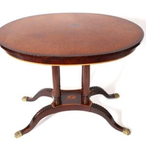 Oval wood table with carved legs.