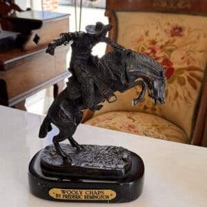 Bronze on marble base after Frederic Remington's "Wooly Chaps”