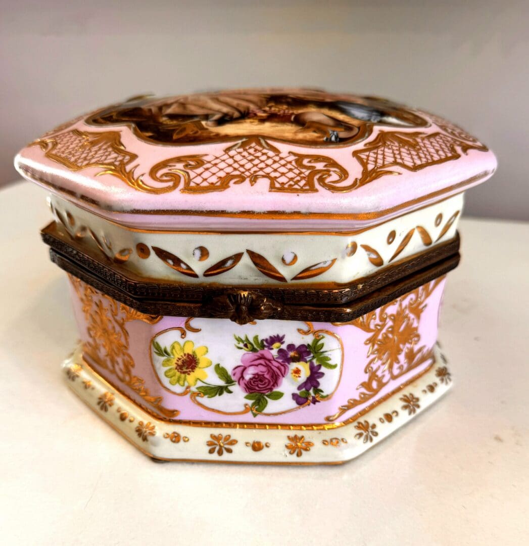 Side profile of antique Sèvres style porcelain box showing pale pink ground, hand-painted floral bouquet cartouche and gilt bronze mounts