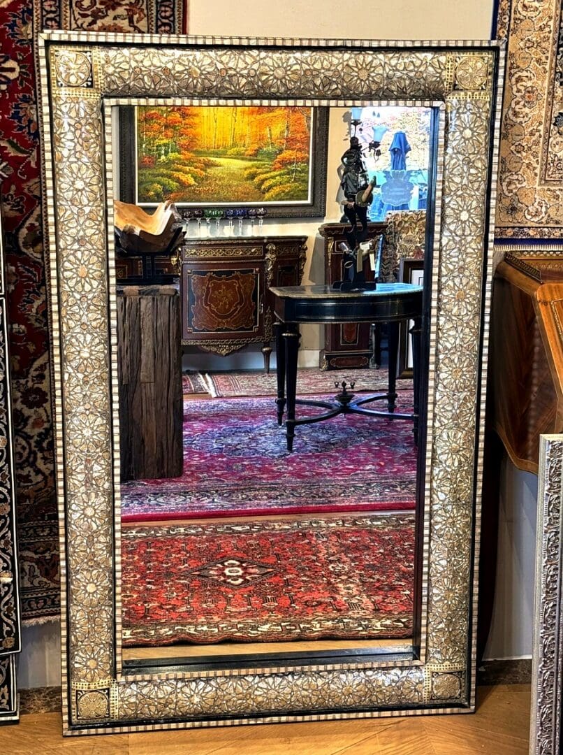 Showroom view of mother of pearl mirror and bone inlaid wall mirror showing intricate star and floral mosaic craftsmanship