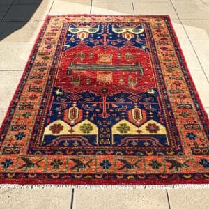 Handmade Persian Gabbeh tribal carpet with deep navy field, brick-red central motif and terracotta border