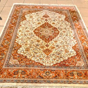 Handmade Persian Tabriz medallion carpet with ivory field, warm copper and terracotta borders and blue detailing