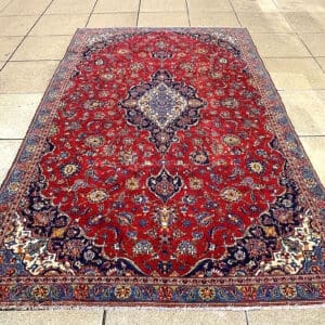 Handmade Persian Kashan Medallion Carpet with deep red field, navy and ivory central medallion, steel blue and gold accents, 10 feet 7 inches by 6 feet 8 inches
