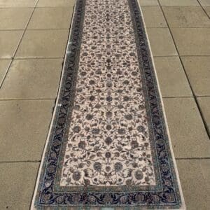 Long Persian hand-finished Silk Qum runner, 13′1″ × 3′3″, with a cream field, intricate vine design and navy and turquoise borders